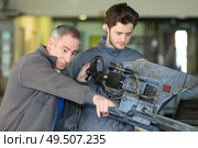 impatient man pointing where apprentice needs to direct machine. Стоковое фото, агентство Ingram Publishing / Фотобанк Лори