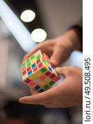 man collects the cube rubik. Intellectual puzzle. Редакционное фото, агентство Ingram Publishing / Фотобанк Лори