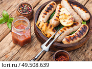 Grilled sausages and vegetables with sauce ketchup on wooden tray.Bbq food. Grilled sausages with vegetables. Стоковое фото, агентство Ingram Publishing / Фотобанк Лори