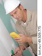 electrician technician fixes the electric cable to the socket. Стоковое фото, агентство Ingram Publishing / Фотобанк Лори