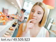 a woman hesitating in shoeshop. Стоковое фото, агентство Ingram Publishing / Фотобанк Лори