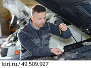 car mechanic replacing oil on engine in garage. Стоковое фото, агентство Ingram Publishing / Фотобанк Лори