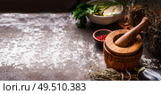 Food background with pestle and mortar, herbs and spices on dark rustic background. Copy space. Стоковое фото, агентство Ingram Publishing / Фотобанк Лори