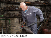 senior blacksmith forging the molten metal. Стоковое фото, агентство Ingram Publishing / Фотобанк Лори