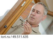 man fixing the door handle. Стоковое фото, агентство Ingram Publishing / Фотобанк Лори