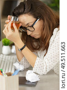 frustrated businesswoman holding drink sitting at office desk. Стоковое фото, агентство Ingram Publishing / Фотобанк Лори