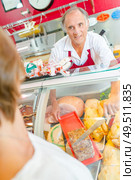 a butcher is serving a client. Стоковое фото, агентство Ingram Publishing / Фотобанк Лори