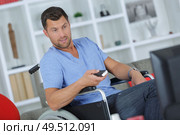 man on the wheelchair watching television. Стоковое фото, агентство Ingram Publishing / Фотобанк Лори