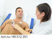 nurse attching pads to patients chest to monitor his heart. Стоковое фото, агентство Ingram Publishing / Фотобанк Лори