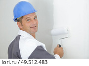 happy worker painting wall in room. Стоковое фото, агентство Ingram Publishing / Фотобанк Лори