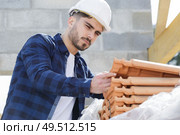 male builder is checking tiles. Стоковое фото, агентство Ingram Publishing / Фотобанк Лори