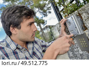 Handyman repairing an intercom system. Стоковое фото, агентство Ingram Publishing / Фотобанк Лори