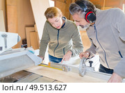 craftsman and carpenter working as a team cutting wood. Стоковое фото, агентство Ingram Publishing / Фотобанк Лори