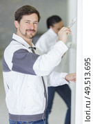 happy master standing with paint and brushes in paint shop. Стоковое фото, агентство Ingram Publishing / Фотобанк Лори