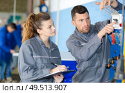 technician showing electrical switches to apprentice. Стоковое фото, агентство Ingram Publishing / Фотобанк Лори