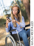 young woman on the wheelchair strolling into the woods. Стоковое фото, агентство Ingram Publishing / Фотобанк Лори