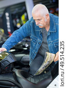 senior man looking at touring bike in shorwoom. Стоковое фото, агентство Ingram Publishing / Фотобанк Лори