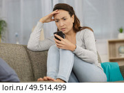 concerned woman reading message on her smartphone. Стоковое фото, агентство Ingram Publishing / Фотобанк Лори