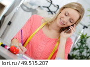 portrait of beautiful seamstress talking on the phone. Стоковое фото, агентство Ingram Publishing / Фотобанк Лори