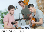three young men playing guitars and singing. Стоковое фото, агентство Ingram Publishing / Фотобанк Лори
