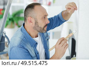 man holding a paint brush. Стоковое фото, агентство Ingram Publishing / Фотобанк Лори