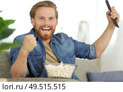 picture of triumphant male holding remote. Стоковое фото, агентство Ingram Publishing / Фотобанк Лори