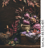 Autumn still life with purple fruits and vegetables on dark wooden table with fall leaves. Garden harvest. Organic farm production. Cozy home. Стоковое фото, агентство Ingram Publishing / Фотобанк Лори