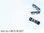 bowl of popcorn, nd remote control for TV and 3d glasses over blue background with copy space, movie and cinema concept. popcorn and 3d glasses. Стоковое фото, агентство Ingram Publishing / Фотобанк Лори