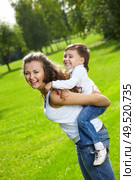 Cheerful mum and son frolic in a summer garden. Стоковое фото, агентство Ingram Publishing / Фотобанк Лори