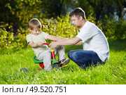 Father learns the son to go by a bicycle, outdoor. Стоковое фото, агентство Ingram Publishing / Фотобанк Лори