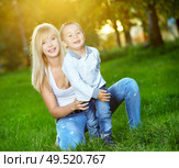 Young mum with the small son are amused in a summer garden. Стоковое фото, агентство Ingram Publishing / Фотобанк Лори