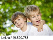 Two cheerful boys embrace in a summer garden. Стоковое фото, агентство Ingram Publishing / Фотобанк Лори