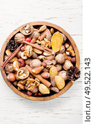 Nuts mix in a wooden plate.Different types of nuts.. Assorted nuts on white. Стоковое фото, агентство Ingram Publishing / Фотобанк Лори