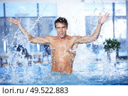 The attractive guy splashes water in pool. Стоковое фото, агентство Ingram Publishing / Фотобанк Лори