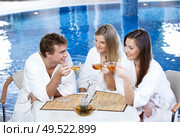 Friends communicate over a cup of tea against pool. Стоковое фото, агентство Ingram Publishing / Фотобанк Лори