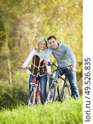 Young couple on bicycles in the park. Стоковое фото, агентство Ingram Publishing / Фотобанк Лори
