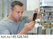 man taking picture of a boiler. Стоковое фото, агентство Ingram Publishing / Фотобанк Лори