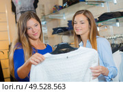 two friends are admiring a dress. Стоковое фото, агентство Ingram Publishing / Фотобанк Лори