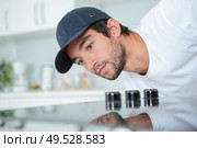 Fitter checking installation of hob. Стоковое фото, агентство Ingram Publishing / Фотобанк Лори