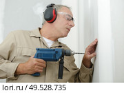 man drilling the wall with drill perforator. Стоковое фото, агентство Ingram Publishing / Фотобанк Лори