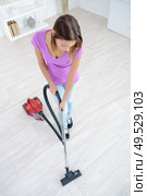 smiling young woman hoovering apartment. Стоковое фото, агентство Ingram Publishing / Фотобанк Лори
