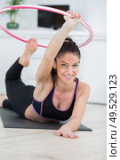 woman exercising at home on floor with hula hoop. Стоковое фото, агентство Ingram Publishing / Фотобанк Лори