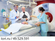 Medical staff stood around patient having scan. Стоковое фото, агентство Ingram Publishing / Фотобанк Лори