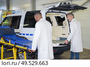 Paramedics wheeling stretcher to ambulance. Стоковое фото, агентство Ingram Publishing / Фотобанк Лори