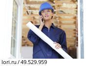 woman builder with blueprints using smart phone. Стоковое фото, агентство Ingram Publishing / Фотобанк Лори