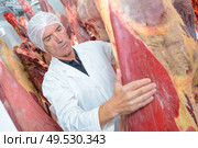 a man holding animal carcass. Стоковое фото, агентство Ingram Publishing / Фотобанк Лори