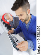 young male technician repairing air conditioner. Стоковое фото, агентство Ingram Publishing / Фотобанк Лори