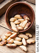 Tasty peeled brazil nut in bowl on old wooden table. Brazil nut or Bertholletia. Стоковое фото, агентство Ingram Publishing / Фотобанк Лори