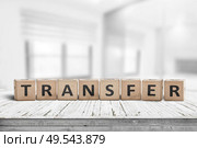 Transfer sign on a wooden table in a bright offce with windows in the background. Стоковое фото, агентство Ingram Publishing / Фотобанк Лори