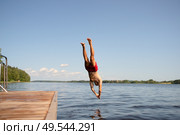 Athletic man diving headfirst from a pier into the lake. Summer day, strong motion and energy. Стоковое фото, фотограф Скоробогатова Е. / Фотобанк Лори